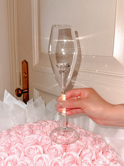 ‘100-Carat’ Diamond Champagne Flute Set of 2 atop a massive pink rose bouquet.